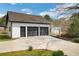 Detached two-car garage with black doors and a concrete driveway, surrounded by mature trees at 813 Sandy Creek Rd, Fayetteville, GA 30214