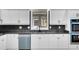 Modern kitchen features new stainless steel appliances, black backsplash and bright white cabinetry at 813 Sandy Creek Rd, Fayetteville, GA 30214
