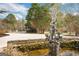 Backyard pond with statue, mature landscaping, and stone retaining wall at 813 Sandy Creek Rd, Fayetteville, GA 30214