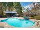 In-ground pool featuring a diving board, tanning ledge, cabana, and stone water feature at 813 Sandy Creek Rd, Fayetteville, GA 30214