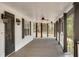 View of long, covered porch with ceiling fans, dark columns, balusters, and outdoor sconces at 813 Sandy Creek Rd, Fayetteville, GA 30214