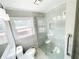 The renovated bathroom showcases a modern glass shower, white tiled walls, and natural light at 1584 Hebron Ln, Riverdale, GA 30296