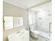 This bathroom features a glass shower, handicap bar, large mirror and sink with vanity at 1584 Hebron Ln, Riverdale, GA 30296