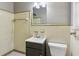Bathroom with tiled walls, grey vanity, toilet, and mirror at 4442 Mark Anthony Ct, Decatur, GA 30035