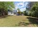 Manicured backyard showing the patio and spacious green lawn surrounded by mature trees and landscaping at 5755 Haterleigh Dr, Alpharetta, GA 30005