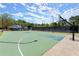Community basketball court with black fencing and lighting, surrounded by trees and landscaping at 5755 Haterleigh Dr, Alpharetta, GA 30005