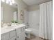 This bathroom features a white vanity, framed mirror, and shower-tub combination at 5755 Haterleigh Dr, Alpharetta, GA 30005