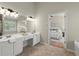 Bright bathroom with double sinks, and decorative lighting fixtures, and a view to the main bedroom at 5755 Haterleigh Dr, Alpharetta, GA 30005