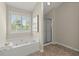 This relaxing bathroom features a garden tub, separate shower, and window with privacy shutters at 5755 Haterleigh Dr, Alpharetta, GA 30005