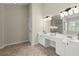 This bathroom features double sinks, large mirror, white cabinets and tile flooring at 5755 Haterleigh Dr, Alpharetta, GA 30005