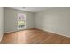Neutral colored bedroom with wood floors and a double window for great natural lighting at 5755 Haterleigh Dr, Alpharetta, GA 30005