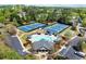 Aerial view of community pool, clubhouse, tennis courts, parking and playground in a lush, tree-filled neighborhood at 5755 Haterleigh Dr, Alpharetta, GA 30005