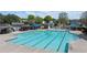 Community pool with lap lanes, umbrellas and lounge chairs in a fenced-in area with mature trees at 5755 Haterleigh Dr, Alpharetta, GA 30005