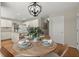 Cozy dining area features a round wood table, seating for four, and modern light fixture at 5755 Haterleigh Dr, Alpharetta, GA 30005
