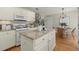 Eat-in kitchen includes an island with granite countertops, white cabinets, and stainless appliances at 5755 Haterleigh Dr, Alpharetta, GA 30005