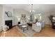 Bright living room showcases neutral decor, hardwood floors, a fireplace, and plenty of seating at 5755 Haterleigh Dr, Alpharetta, GA 30005