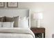 Close up of bedroom featuring a lamp, nightstand, decor, and a cozy bed at 5755 Haterleigh Dr, Alpharetta, GA 30005