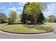 Well-manicured neighborhood entrance with lush landscaping and signature brick and stone signage under a sunny sky at 5755 Haterleigh Dr, Alpharetta, GA 30005