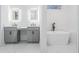 Modern bathroom featuring a soaking tub, double vanity with lit mirrors, and stylish design at 2195 Springdale Sw Rd, Atlanta, GA 30315
