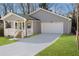 Well-maintained gray home featuring an attached garage and a charming front porch, complemented by a lush green lawn at 2195 Springdale Sw Rd, Atlanta, GA 30315