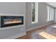 Modern electric fireplace nestled in a gray wall with hardwood flooring and natural light from the windows at 2195 Springdale Sw Rd, Atlanta, GA 30315