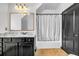 Bathroom with dark vanity, tiled floors, shower with curtain and a large mirror at 5204 Heron Bay Blvd, Locust Grove, GA 30248