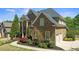 Side view of an elegant brick home with lush landscaping and an attached two-car garage at 5204 Heron Bay Blvd, Locust Grove, GA 30248