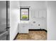 Clean laundry room featuring white cabinets, a window, and tile floors at 5204 Heron Bay Blvd, Locust Grove, GA 30248