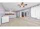 Open concept living room with stairs, kitchen, ceiling fan, and grey walls at 5204 Heron Bay Blvd, Locust Grove, GA 30248