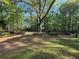 Secluded backyard featuring mature trees, azaleas, and a distant shed at 5254 Franklin Goldmine Rd, Cumming, GA 30028
