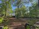 Extensive backyard with mature trees, a wooden fence, storage building and a gated entrance at 5254 Franklin Goldmine Rd, Cumming, GA 30028