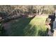 Large backyard with a wooden deck overlooking a vast lawn, surrounded by trees and fencing at 5254 Franklin Goldmine Rd, Cumming, GA 30028