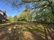 Expansive backyard featuring mature trees, a wooden fence, and verdant green grass at 5254 Franklin Goldmine Rd, Cumming, GA 30028