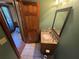 Cozy powder room with a granite vanity, decorative mirror, tile flooring, and green accent wall at 5254 Franklin Goldmine Rd, Cumming, GA 30028