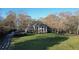 Classic brick home with a columned front porch and mature trees, set on a sprawling green lawn at 5254 Franklin Goldmine Rd, Cumming, GA 30028