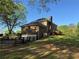 A brick two-story home with a large deck and backyard surrounded by a black wooden fence at 5254 Franklin Goldmine Rd, Cumming, GA 30028