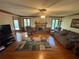 Cozy living room featuring a fireplace, ceiling fan, wood trim, and natural light at 5254 Franklin Goldmine Rd, Cumming, GA 30028