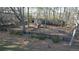 Rustic outbuildings and fencing in wooded property with a swing set at 5254 Franklin Goldmine Rd, Cumming, GA 30028