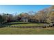 Rolling green acreage with wooden fence, and the stately brick home in the background at 5254 Franklin Goldmine Rd, Cumming, GA 30028