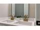 Elegant bathroom with double sinks, gold fixtures, and a stylish mirror, perfect for a modern home at 5728 Norman Ct, Atlanta, GA 30349