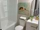 Bright white bathroom with a shower-tub combo and a charming robin painting on the wall at 5728 Norman Ct, Atlanta, GA 30349