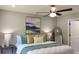 Bedroom featuring a ceiling fan, an abstract painting and a king-sized bed with decorative pillows and lamps at 5728 Norman Ct, Atlanta, GA 30349