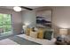 Bright bedroom with a large window, ceiling fan, modern art piece, and a king bed with stylish bedding at 5728 Norman Ct, Atlanta, GA 30349