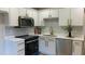 Modern kitchen with white cabinets, quartz countertops, gold hardware, and stainless steel appliances at 5728 Norman Ct, Atlanta, GA 30349