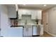 Well-lit kitchen boasts white cabinets, stainless steel appliances, and gold hardware accents at 5728 Norman Ct, Atlanta, GA 30349