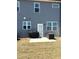 Backyard featuring gray siding, a small patio, storage box, and an enclosed grill at 860 Point Place Dr, Loganville, GA 30052