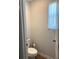 Powder room with toilet and window at 860 Point Place Dr, Loganville, GA 30052