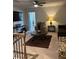 A well-lit living room features a dark leather couch, decorative rug, ceiling fan, and a cozy armchair at 860 Point Place Dr, Loganville, GA 30052