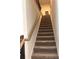 Carpeted stairway with wood banister leading to the upper level of the home at 860 Point Place Dr, Loganville, GA 30052