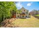 Spacious backyard with a lush lawn, mature trees, and a view of the home's deck at 3819 Meandering Sw Way, Lilburn, GA 30047